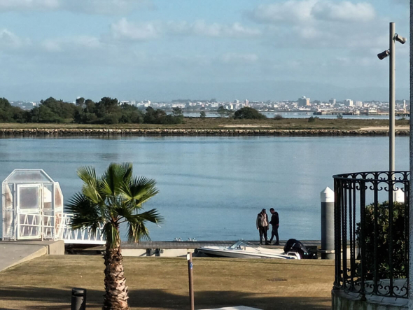 The image shows the view across the Ria de Aveiro (Aveiro lagoon) from the upper floor of Casa dos Jacintos in São Jacinto, Portugal. In the background: the city of Aveiro. Photo: Casa dos Jacintos